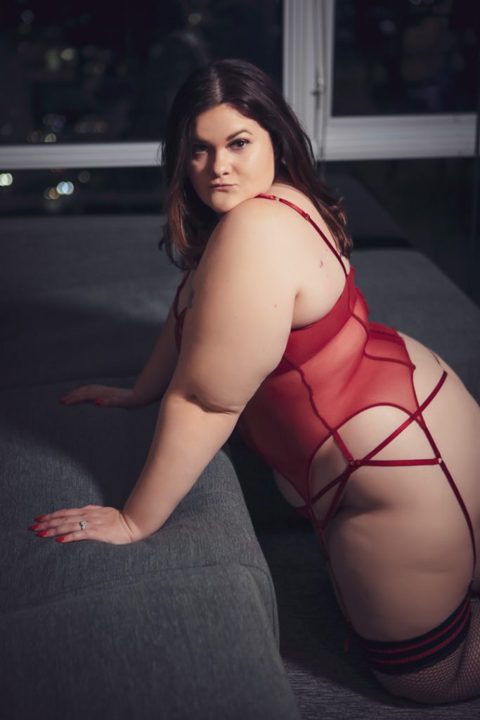 Boudoir photo with woman in red bodysuit