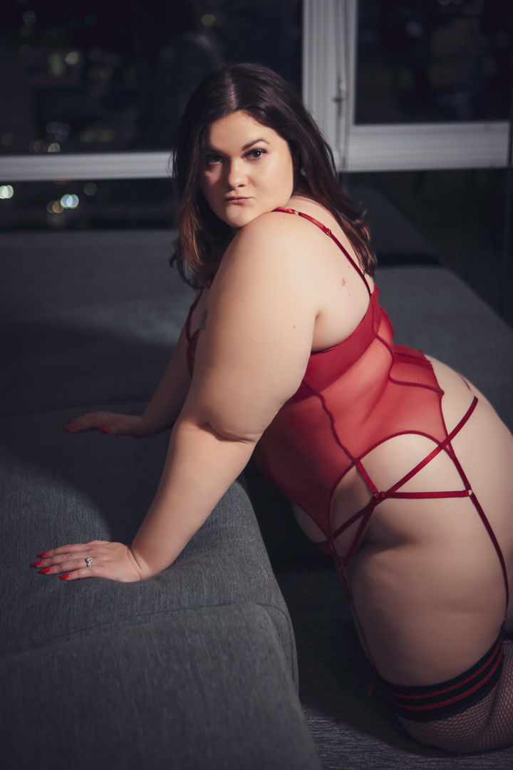 Boudoir photo with woman in red bodysuit